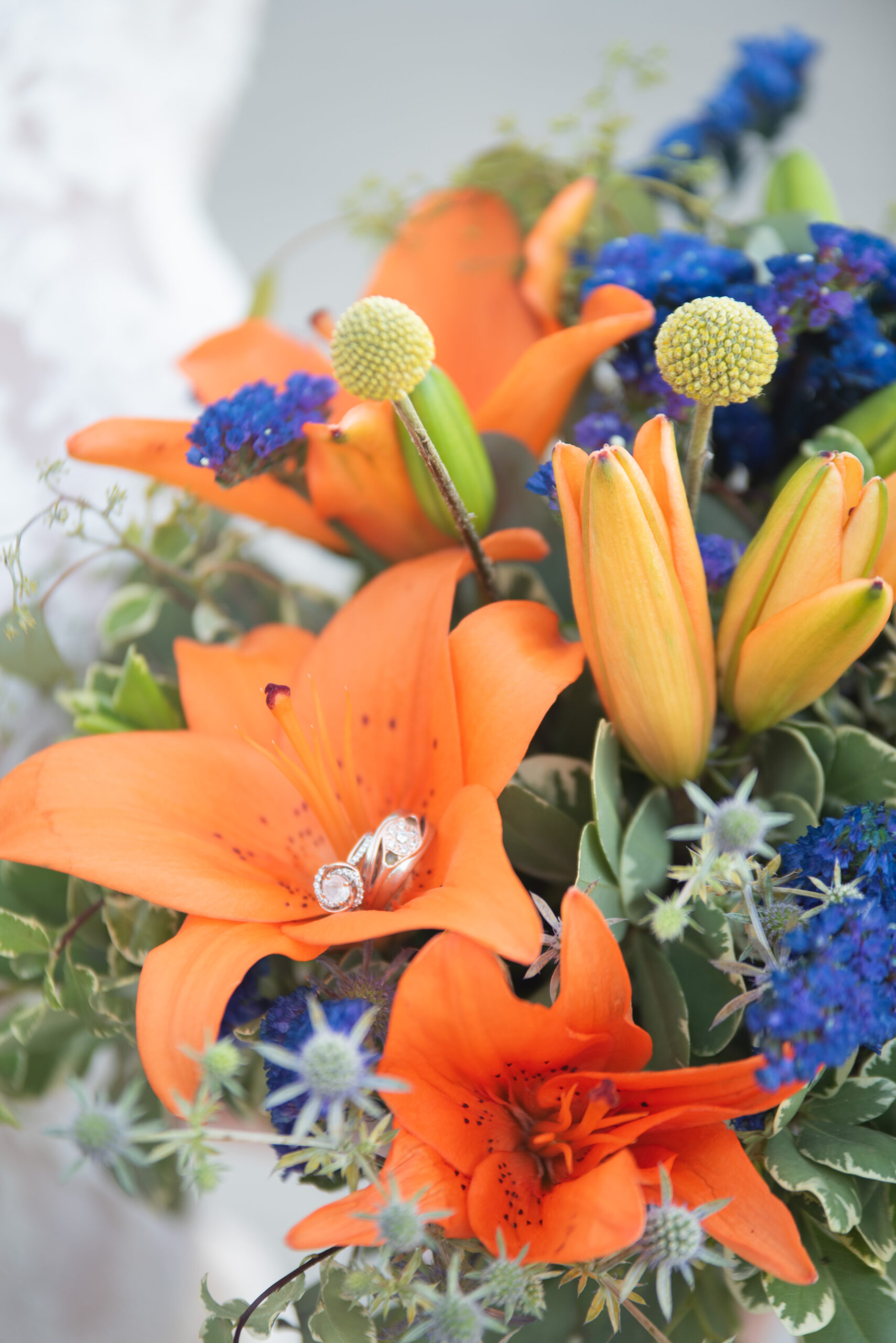 Detailed photo of bridal bouquet with tiger lillies, thistle and other florals  
